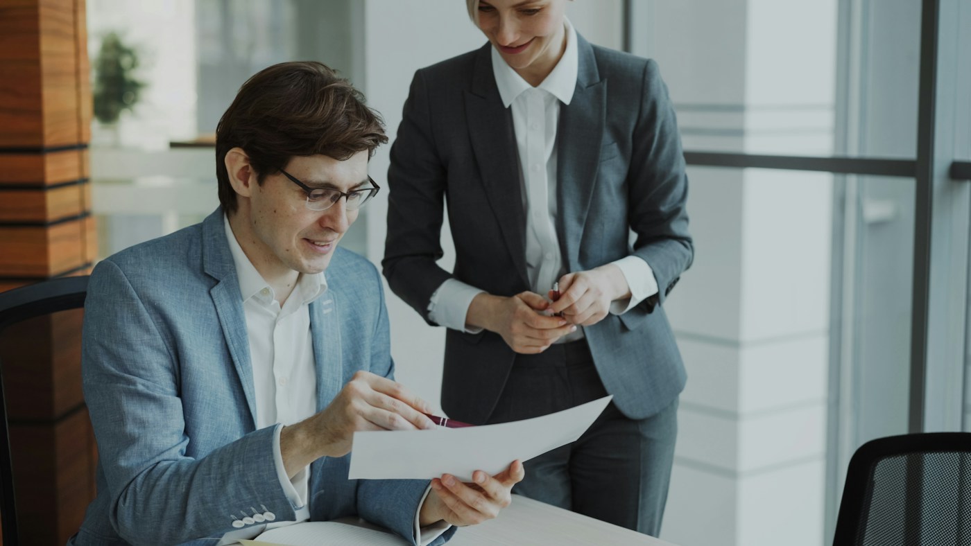 Professionals discussing a document together in a bright office.