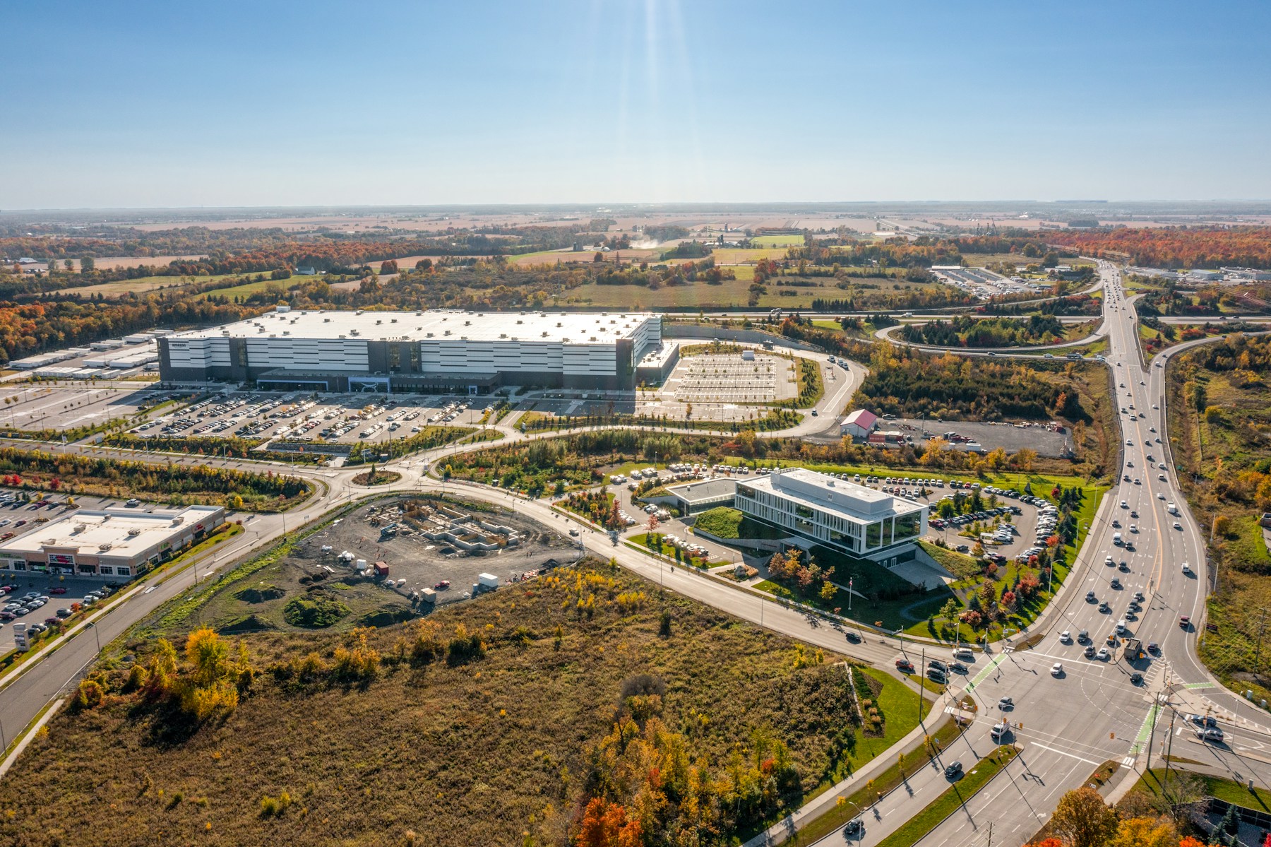 Aerial view of commercial buildings, surrounding land and road access.